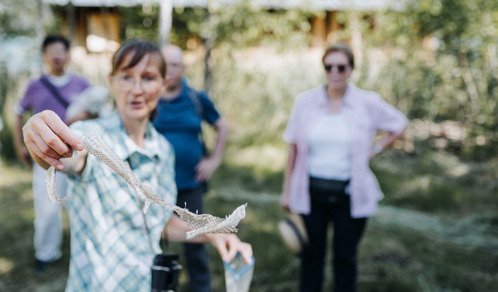 Ausflüge in Kärnten: Manuela Natur Guide vom Weissensee, zeigt während der Genussfloss Tour eine alte Schlangenhaut, die sie in der Region Weissensee gefunden hat