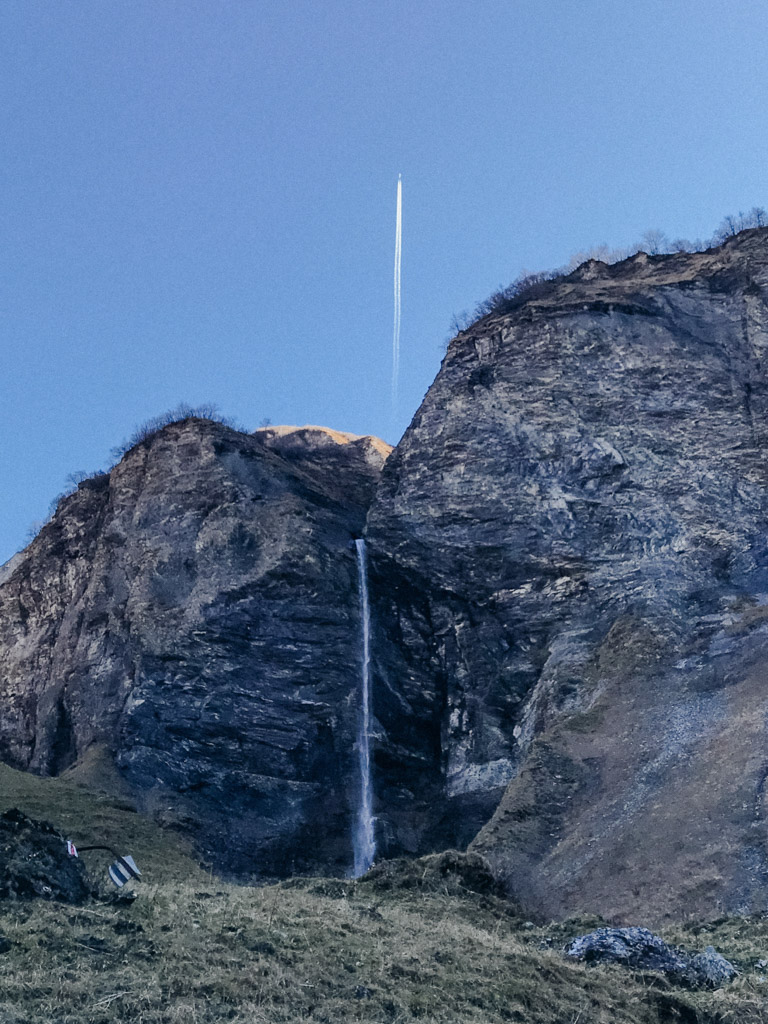 Blick auf den Wasserfall in der Wasserfall Arena Batöni mit drüberfliegendem Flugzeug