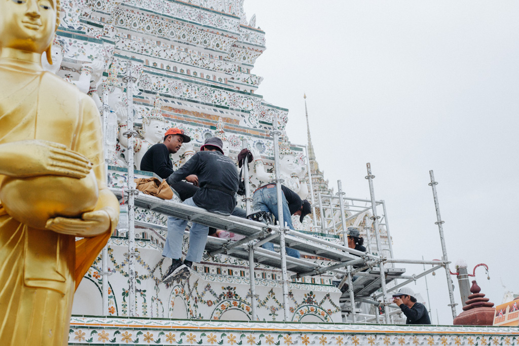 fleissige Handwerker arbeiten am Tempel des Wat Arun in Bangkok, eine beliebte Sehenswürdigkeit 
