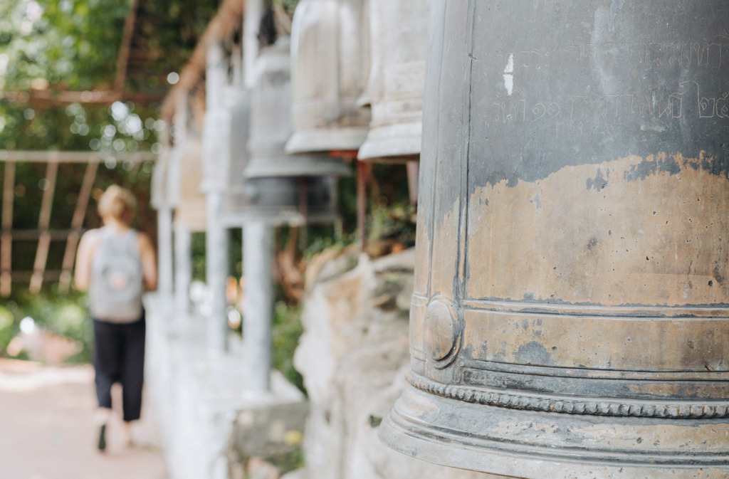 Ein Tempelbesuch für deine Bangkok Tipps ist der Wat Saket, wie hier mit den buddhistischen Glocken und der Frau im Hintergrund