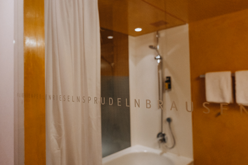 Badezimmer mit Glastür und Beschriftung im Bregenzerwald Zimmer des Hotel Krone in Hittisau