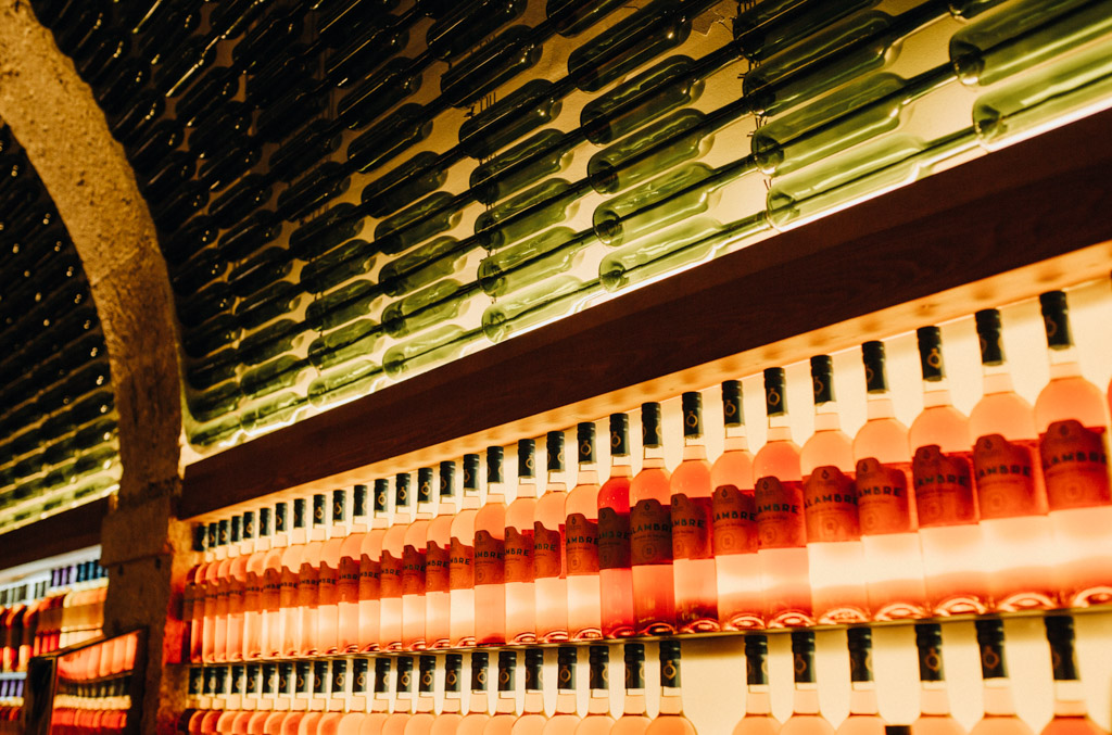 grüne und rote Flaschen wurden gestapelt oder nebeneinander gestellt und sind die Deko für to the wine in Lissabon, ein toller Fotospot für Detailaufnahmen