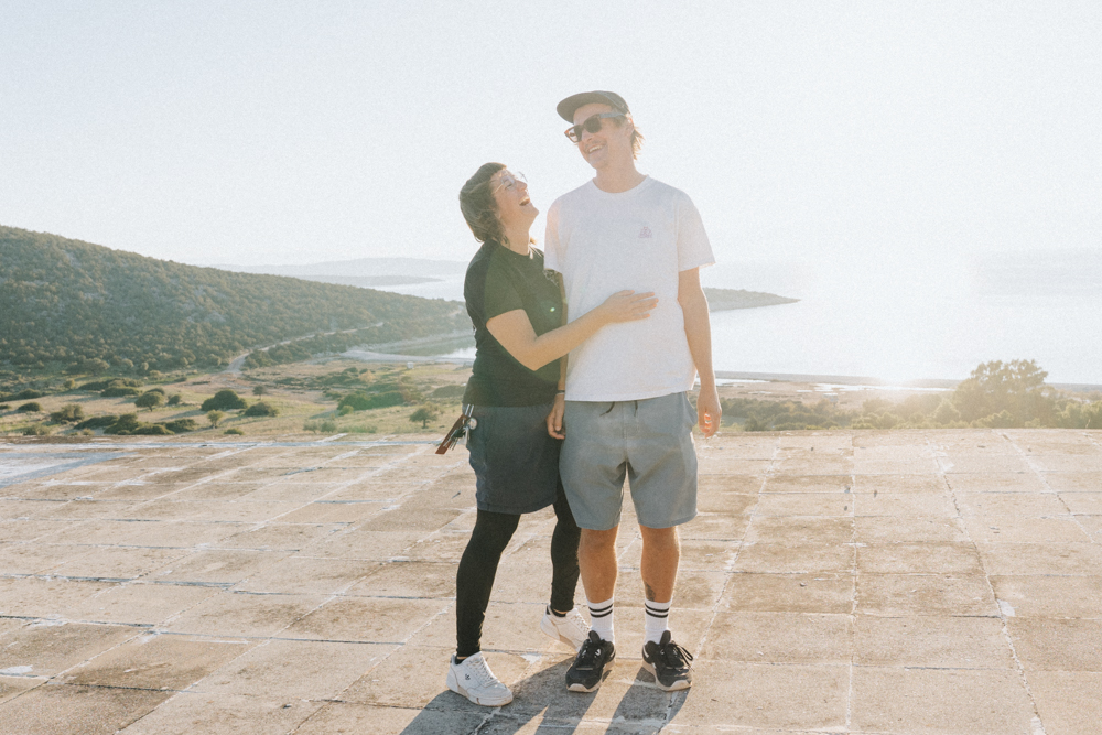 Lisa Ludwig und Dominic Wolf im Gegenlicht bei Sonnenuntergang auf Lost Place Hoteldach Peloponnes Griechenland