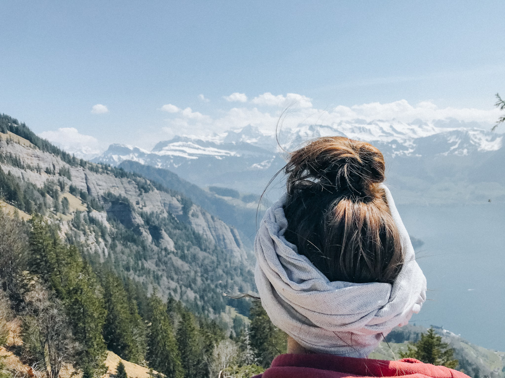 Lisa Ludwig ist Reisebloggerin, Fotografin und schaut mit ihrem Turban und Dutt auf die Zentralschweizer Alpen während des Winterwandern in der Schweiz