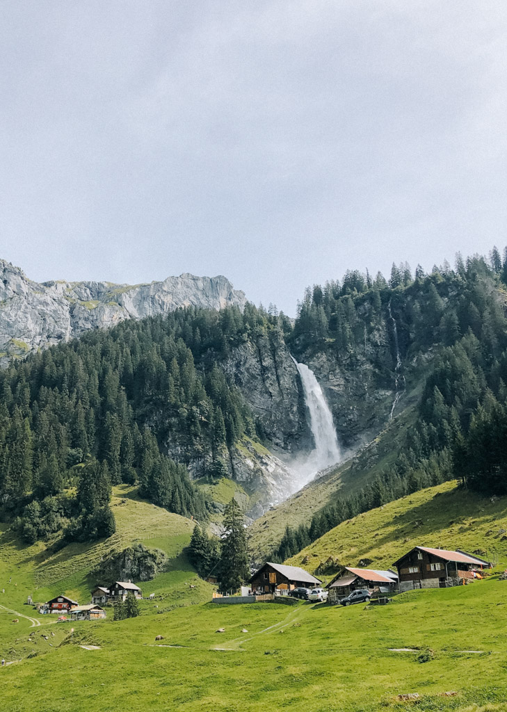 Blick auf das Dorf bekannte Dorf Äsch in der Schweiz mit berühmten Wasserfall Stäubifall im Hintergrund