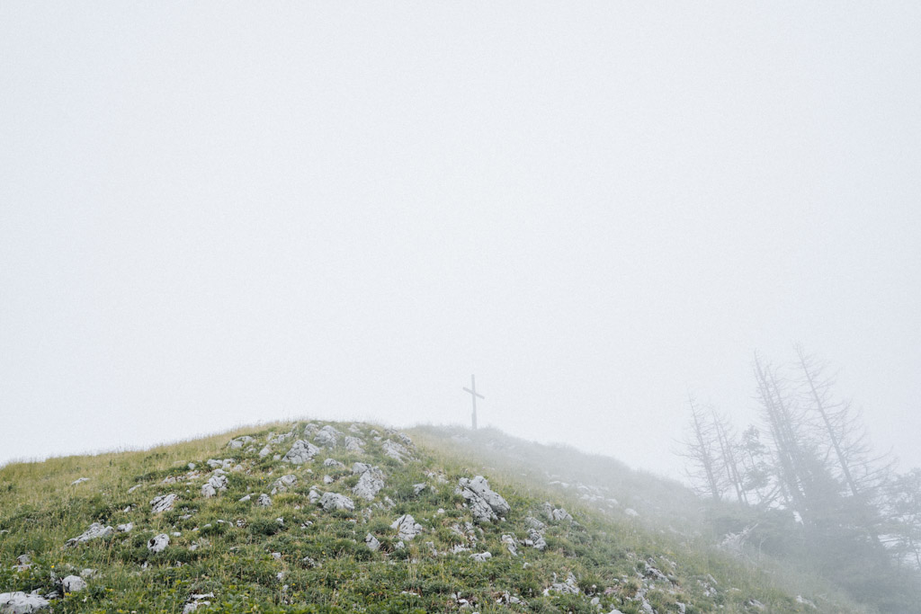 schönsten Wanderungen der Schweiz auf dem Glaubenbielenpass mit viel Nebel und Blick auf das Gipfelkreuz des Rotspitz Berg