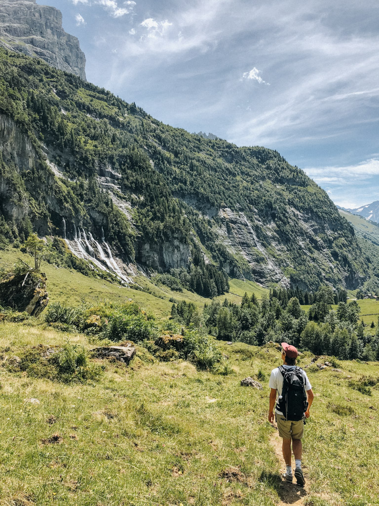 Dominic Wolf, Freund von Reisebloggerin Lisa Ludwig, blickt auf die Jungibachfälle während der schönsten Wanderung der Schweiz im Schwarzental 