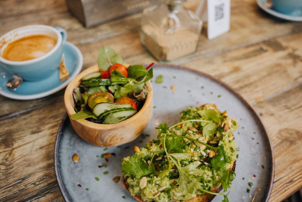 The Urban Garden: Avocado Toast mit frischem Salat auf dem Teller im Restaurant