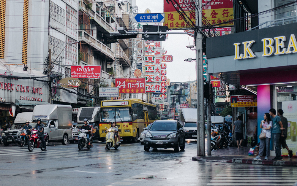 Straßen voller Neonlichter, hupenden Verkehrsteilnehmern und Garküchen in Chinatown Bangkok