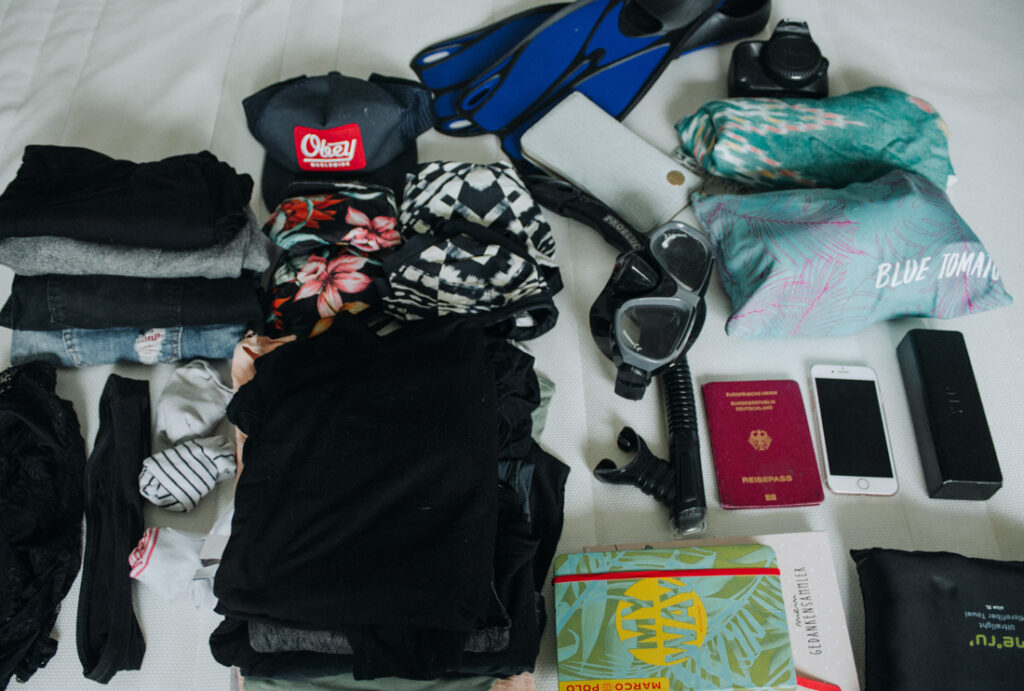 Wichtige Dinge wie Reisepass, Reisehandtuch und Kleidung, die in den Reiserucksack für die Thailand Packliste gehören