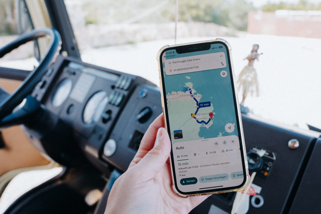 Lisa sucht Wegbeschreibung auf dem Handy beim Sardinien Roadtrip mit dem Camper