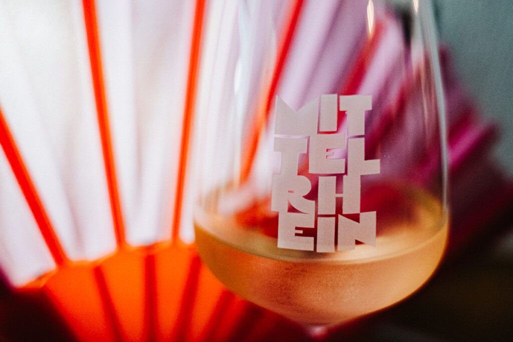 Glas Weißwein bei der Weinverkostung am Mittelrhein mit Logo der Region